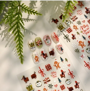 Detail of Christmas nail stickers featuring gingerbread man and gold reindeer patterns