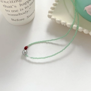 Détail du collier avec perles de rocaille menthe, perle grise et agate rouge