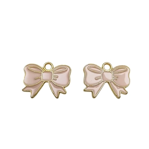 Macro shot of two pink enamel butterfly pendants with gold metal edges for DIY jewelry