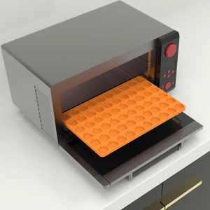 Orange pumpkin silicone mold tray inside a grey oven for baking Halloween candy and chocolate