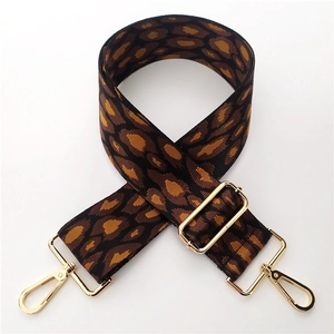 Detail of leopard jacquard wide bag strap with adjustable gold buckle and spring hook