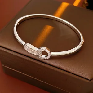 Silver interlocking circle bangle with pave cubic zirconia on a premium leather box