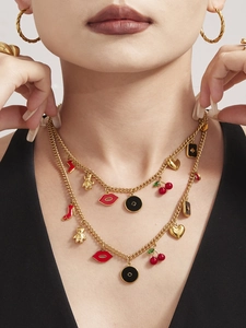 Nahaufnahme einer zweilagigen Goldkette mit roten High-Heel- und Emaille-Anhängern