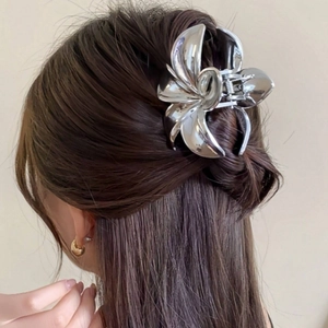 Dettaglio di un fermaglio per capelli in metallo argento a forma di fiore su capelli raccolti