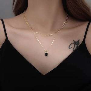 Double-layered gold necklace with geometric links and a black rectangular pendant