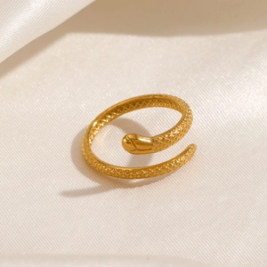 Elegant gold snake open ring with intricate scale texture on a soft silk background