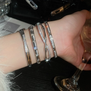 Close-up of a silver zircon bangle set including bamboo and crisscross designs for women