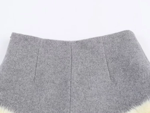 Detailed view of gray wool fabric with premium beige faux fur trim on the hemline