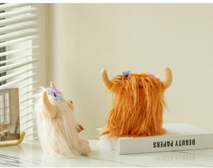 Detailed view of white and ginger highland cow plush toys with floral crowns on a white table