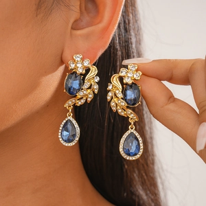 Macro shot of vintage gold drop earrings with deep blue crystals and rhinestones