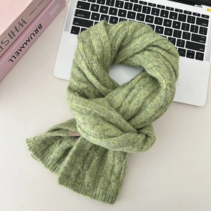 Detailed close-up of moss green ribbed knit texture on a soft wool-like winter scarf