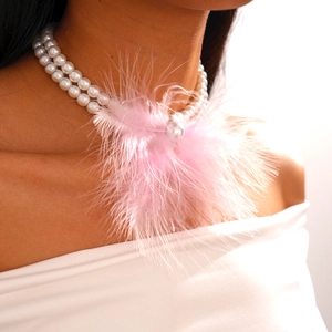 Detailed close-up of double-layer pearl necklace featuring a soft pink feather pendant