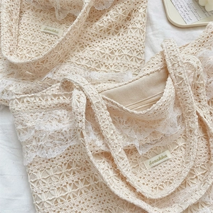 Detail of crochet lace tote bag with internal zipper pocket and floral hollow patterns