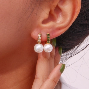 Detail of 18K gold U-shape earrings featuring micro-set green gems and white pearls
