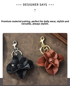 Detail of leather camellia flower keychains in black and brown with lychee grain texture