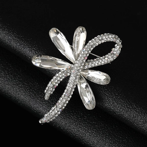 Macro shot of silver bowknot brooch with clear crystals and rhinestones on black leather