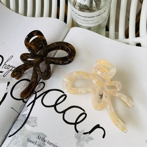 Detail of tortoise shell and ivory acetate butterfly hair claws on an aesthetic magazine