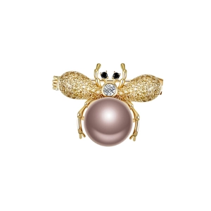 Golden bee brooch with lavender pearl body and shimmering crystal wings on white base