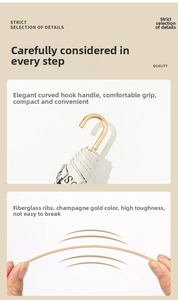 Detail of elegant gold hook handle and high toughness fiberglass ribs on folding umbrella