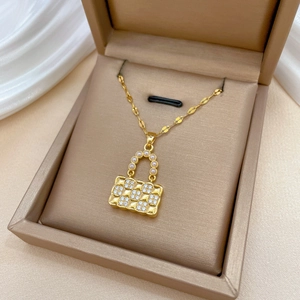 Elegant gold necklace with a handbag pendant featuring pearls and cubic zirconia