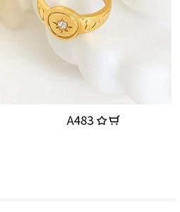 Macro shot of gold sunburst ring with center gemstone on a white sculptural display