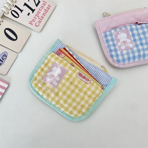 Close-up of quilted yellow and blue plaid coin purse with transparent card slot and zipper