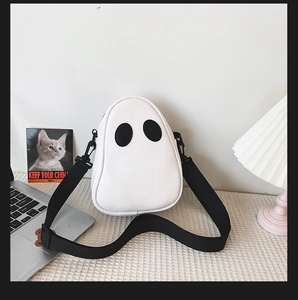 Detailed view of ghost-shaped white PU leather bag with black wide adjustable shoulder strap