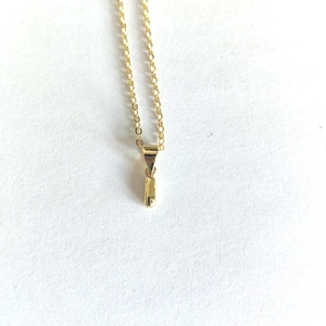 Detailed top view of a minimalist gold necklace with a sleek rectangular pendant on white