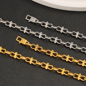 Industrial style bow link bracelets in gold and silver finish on black leather surface