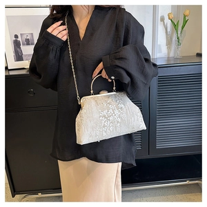 Silver sequin evening bag featuring a vintage metal clasp and a delicate chain strap