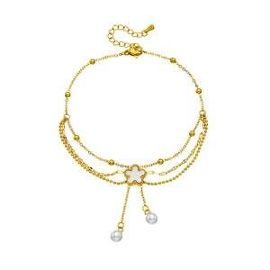 Gold multi-layer anklet featuring shell flower charm and pearl fringe tassels on white background