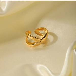 Detail of 18k gold plated criss-cross ring with polished finish on beige silk background