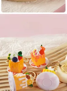 Detailansicht der Mini-Dessert-Kuchen-Schlüsselanhänger mit Fruchtdekor auf Holz