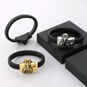 Detail of woven leather bracelet with gold, silver and black lion head metal clasps