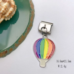 Rainbow hot air balloon charm in colorful enamel on textured background with sea shell