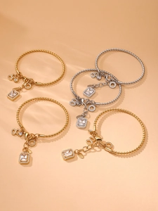 Detailed macro of gold plated stainless steel twisted bangles with zircon pendants