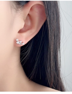 Close-up of S925 sterling silver curved zircon stud earrings worn by a model
