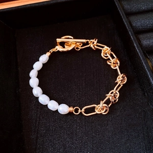 Macro shot of 18k gold plated chain bracelet with white pearls and OT toggle clasp
