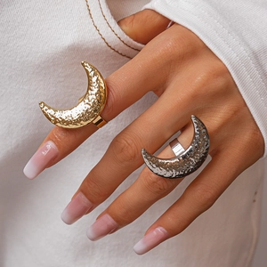 Close-up of gold and silver moon rings with hammered metal texture on model's hand