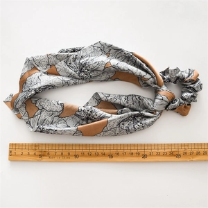 Floral print satin hair tie detail showing smooth texture and large elastic scrunchie