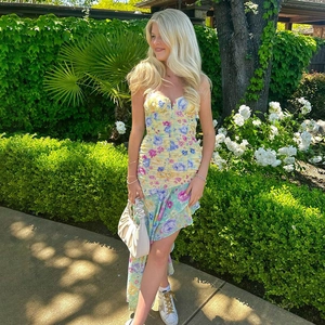 Detail of floral off-shoulder dress with ruffled bust and irregular hem in nature