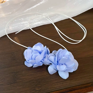 Gros plan de boucles d'oreilles en satin bleu clair avec texture de soie détaillée
