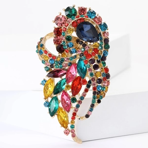 Macro shot of colorful rhinestone cluster on a vintage gold peacock feather brooch