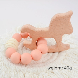 Baby wooden rocking horse teether with pink silicone beads on a white woven coaster