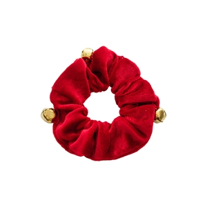 Red velvet Christmas scrunchie with golden bells on white background for festive hair styling