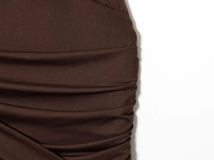 Gros plan du tissu plissé marron foncé montrant la texture fine d'un body sexy