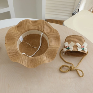 Détail d'un chapeau de paille pour filles et sac assorti avec broderie cerise
