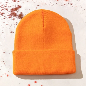 Detail view of orange knit beanie featuring classic rib weave and Halloween blood splatter backdrop