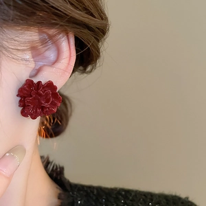 Close-up of elegant burgundy floral stud earrings with glossy multi-layered petals