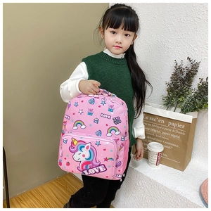Detail of pink unicorn backpack with rainbow patterns held by a child in a cozy setting